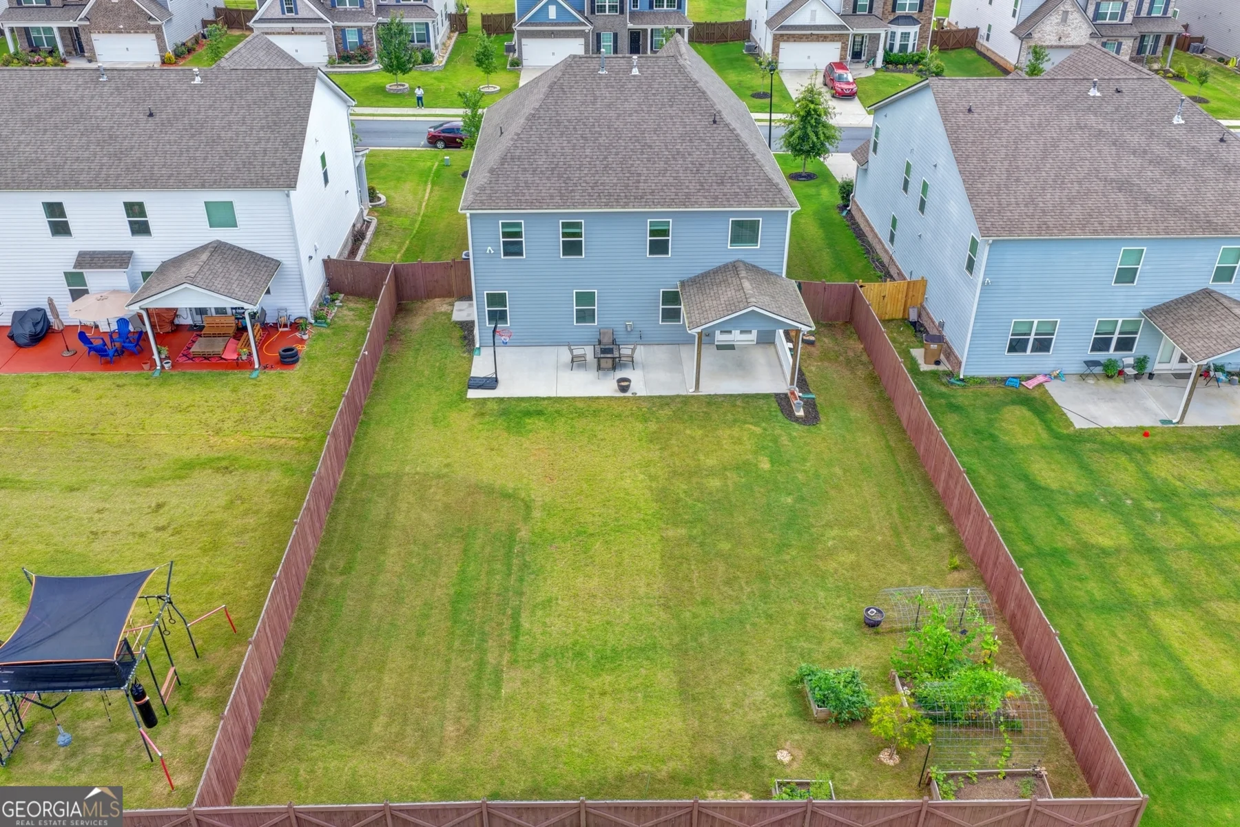 Aerial rear view of the home and neighboring properties