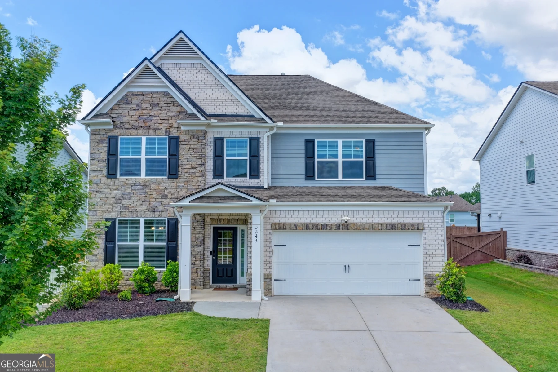 5245 Sargent Drive front exterior with stone accents and landscaped lawn