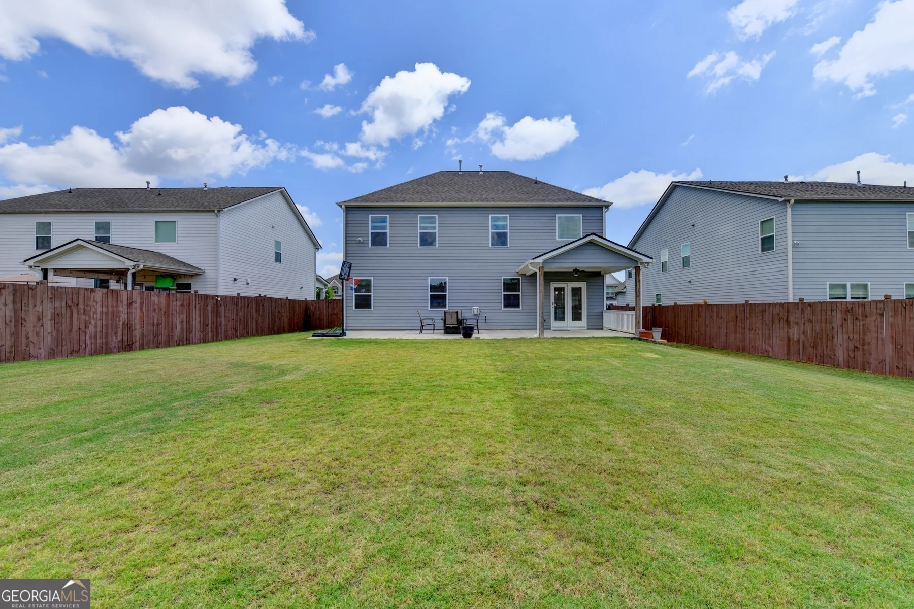 Rear exterior showing covered patio and fenced yard